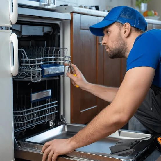 Technician checking an open dishwasher and its lower rack