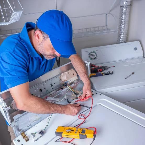 Technician testing the control panel of a laundry appliance